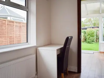 a desk with a chair next to a window at Commonside Cottage in Lytham St Annes
