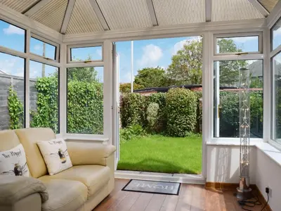 a living room with a couch and a large window at Commonside Cottage in Lytham St Annes