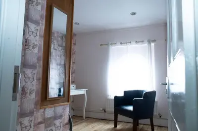 a living room with a chair and a mirror at Spacious house Liverpool city centre L1, sleeps 16 in Liverpool