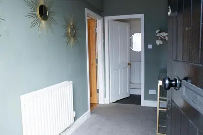 a hallway with a door and a mirror on a wall at Spacious house Liverpool city centre L1, sleeps 16 in Liverpool