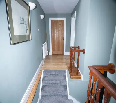 a hallway with blue walls and a staircase with a rug at Spacious house Liverpool city centre L1, sleeps 16 in Liverpool