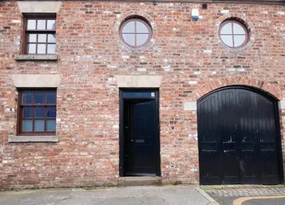 two black doors on a brick building with windows at Spacious house Liverpool city centre L1, sleeps 16 in Liverpool