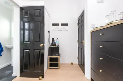 a hallway with a black door and a black cabinet at Christian Retreat Holiday Let in Blackpool