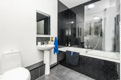 a bathroom with a toilet and a sink and a bath tub at Christian Retreat Holiday Let in Blackpool