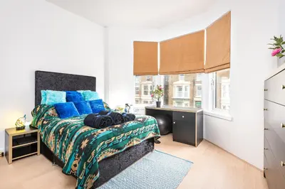 a bedroom with a bed with blue pillows and a desk at Christian Retreat Holiday Let in Blackpool