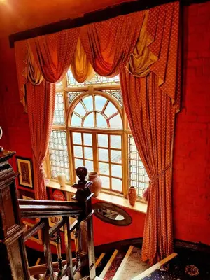 a room with a large window with red curtains at Fifteens of Swinley in Wigan
