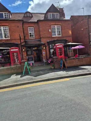 a brick building with red phone booths on the street at Fifteens of Swinley in Wigan