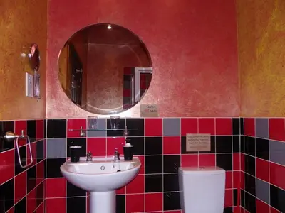 a bathroom with a sink and a mirror and a toilet at Fifteens of Swinley in Wigan