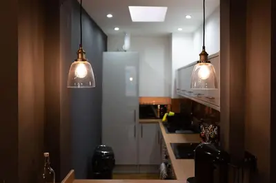 a kitchen with two pendant lights and a refrigerator at Modern 2-Bedroom House in Blackpool Near Seafront in Blackpool