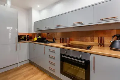 a kitchen with white cabinets and stainless steel appliances at Modern 2-Bedroom House in Blackpool Near Seafront in Blackpool
