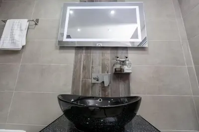 a bathroom with a black sink and a mirror at Modern 2-Bedroom House in Blackpool Near Seafront in Blackpool