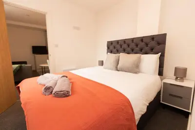 a bedroom with a large bed with towels on it at Boutique 1BR Apartment in the heart of Preston in Preston