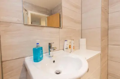 a bathroom with a white sink and a mirror at Boutique 1BR Apartment in the heart of Preston in Preston