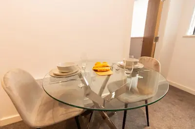 a glass table with two chairs and two cups at Boutique 1BR Apartment in the heart of Preston in Preston