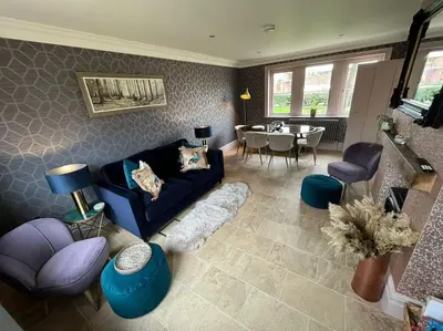 a living room with a blue couch and a table at Cosy hideaway in leafy Lytham in Lytham St Annes