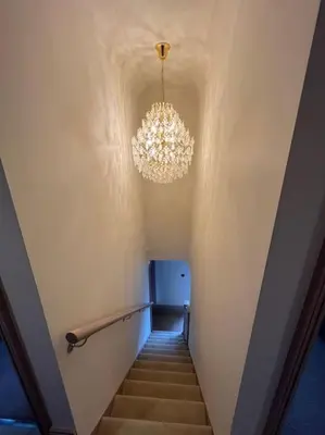 a stairway with a chandelier and a hallway with stairs at Cosy hideaway in leafy Lytham in Lytham St Annes