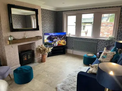 a living room with a blue couch and a tv at Cosy hideaway in leafy Lytham in Lytham St Annes