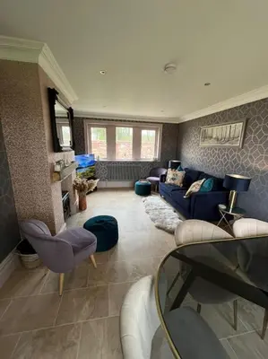 a living room with a blue couch and chairs at Cosy hideaway in leafy Lytham in Lytham St Annes