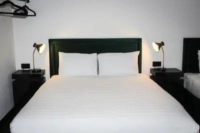 a bedroom with a large bed with two lamps on tables at The Hideaway by Boutique 56 in Liverpool