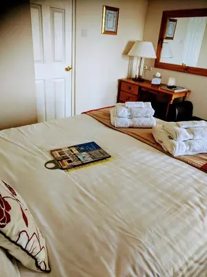 a large white bed in a room with a desk at Craigwell in Morecambe