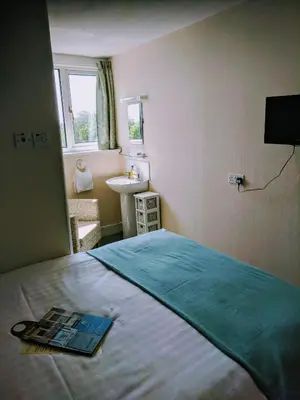 a bedroom with a bed and a sink and a window at Craigwell in Morecambe