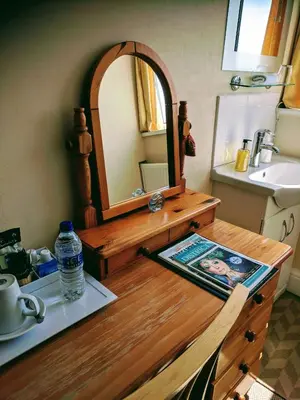 a bathroom with a vanity with a mirror and a sink at Craigwell in Morecambe