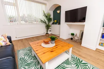 a living room with a coffee table and a tv at Stylish Comfort: 2BR Home in the Heart of Wigan in Pemberton