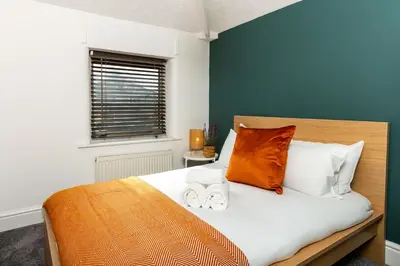 a bedroom with a bed with two towels on it at Stylish Comfort: 2BR Home in the Heart of Wigan in Pemberton