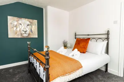 a bedroom with a bed with orange and white pillows at Stylish Comfort: 2BR Home in the Heart of Wigan in Pemberton