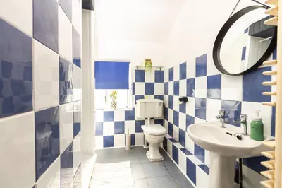 a blue and white bathroom with a toilet and a sink at Stylish Comfort: 2BR Home in the Heart of Wigan in Pemberton