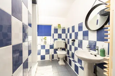 a blue and white bathroom with a toilet and a sink at Stylish Comfort: 2BR Home in the Heart of Wigan in Pemberton
