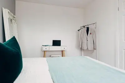 a bedroom with a bed and a suit hanging on a door at Park & Relax in 1bd Central Liverpool home in Liverpool