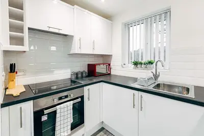 a white kitchen with white cabinets and a sink at Park & Relax in 1bd Central Liverpool home in Liverpool