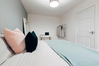 a white bedroom with a bed with pillows on it at Park & Relax in 1bd Central Liverpool home in Liverpool