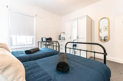 a bedroom with two blue beds and a mirror at Liverpool city centre house, Free parking in Liverpool