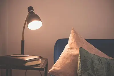a lamp on a table next to a pillow on a couch at Liverpool city centre house, Free parking in Liverpool