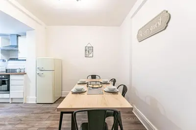 a kitchen with a table and chairs and a refrigerator at Liverpool city centre house, Free parking in Liverpool
