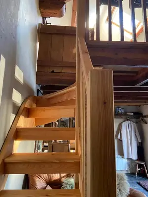 a wooden spiral staircase in a room with a closet at Cartmel Barn: Beckside Stables in Cartmel