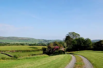 a dirt road in the middle of a field at Cartmel Barn: Beckside Stables in Cartmel