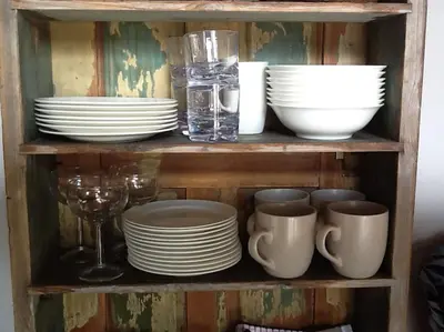 a wooden shelf with plates and cups and glasses at Cartmel Barn: Beckside Stables in Cartmel