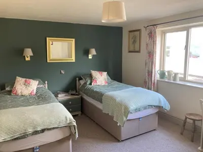 a bedroom with two beds and a window at Brandreth Barn in Burscough