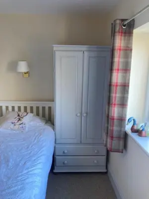 a bedroom with a blue bed and a cabinet at Brandreth Barn in Burscough
