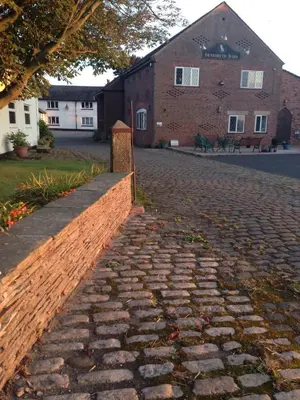 a brick road in front of a brick building at Brandreth Barn in Burscough