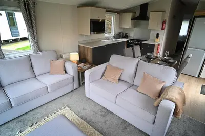 a living room with two couches and a kitchen at Hobbit - Cosy Holiday Lodge with Pool in Longridge