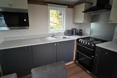 a kitchen with a sink and a stove at Hobbit - Cosy Holiday Lodge with Pool in Longridge
