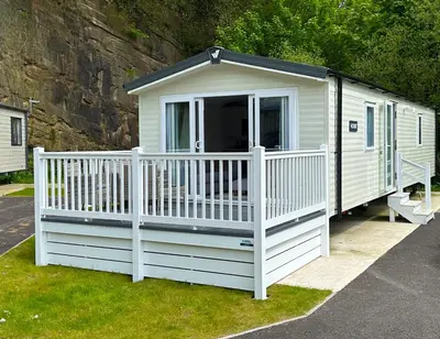a small white house with a white fence at Hobbit - Cosy Holiday Lodge with Pool in Longridge