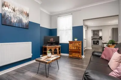 a living room with a couch and a table at Huge 5bedrooms/Ensuite/Liverpool/Ridley rd/Parking in Liverpool