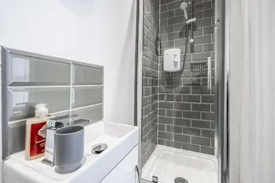 a white bathroom with a shower and a sink at Huge 5bedrooms/Ensuite/Liverpool/Ridley rd/Parking in Liverpool