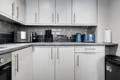 a white kitchen with white cabinets and appliances at Huge 5bedrooms/Ensuite/Liverpool/Ridley rd/Parking in Liverpool