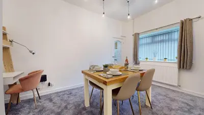 a dining room with a wooden table and chairs at Modernised 3-bedroom Blackburn townhouse sleeps 6 in Rishton